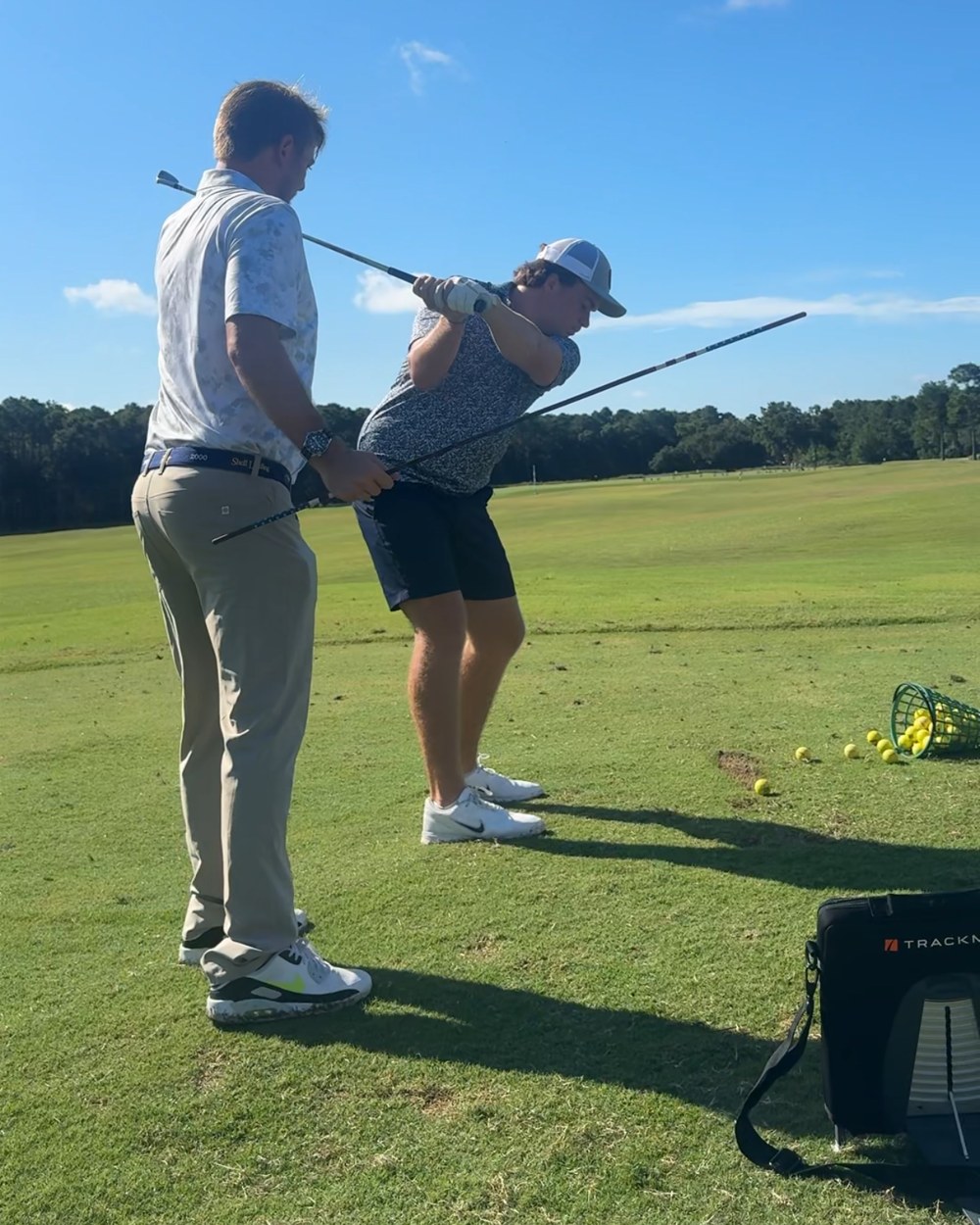 Colin coaching Matt Bond on the range at the top of his backswing