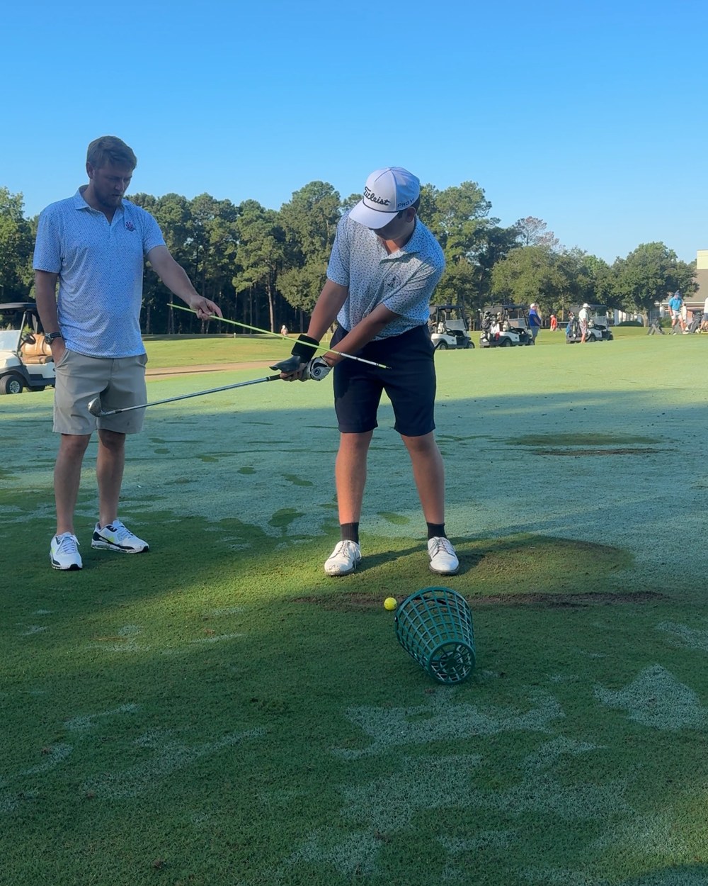 Colin Lockey teaching a student on the range with an alignment stick